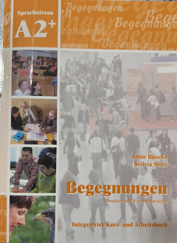 Libro de texto de alemán nivel A2+ que contiene cuaderno de soluciones y audios.